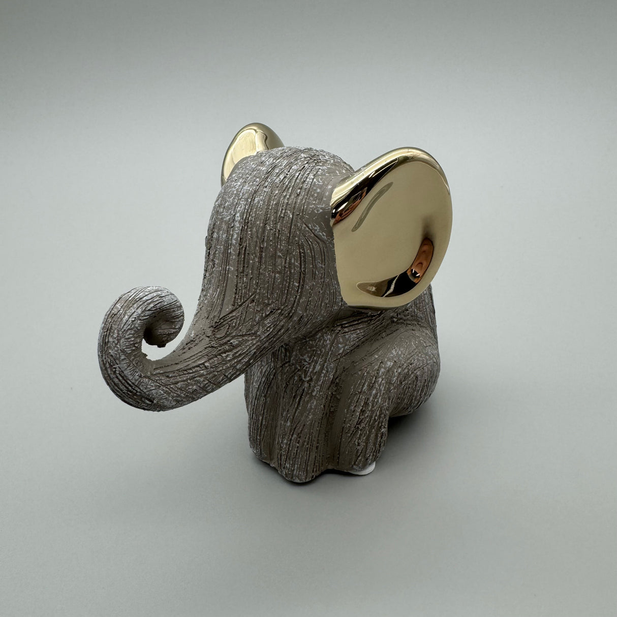 Stilvoller Elefant: 12 cm, Keramik, matte reliefierte Oberfläche, goldene Elemente Rüssel oben von Wimpelberg