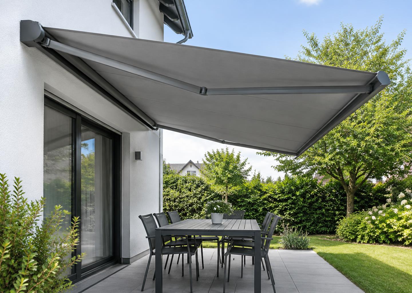 Ausgefahrene Terrassenmarkise über einem Sitzplatz im Garten